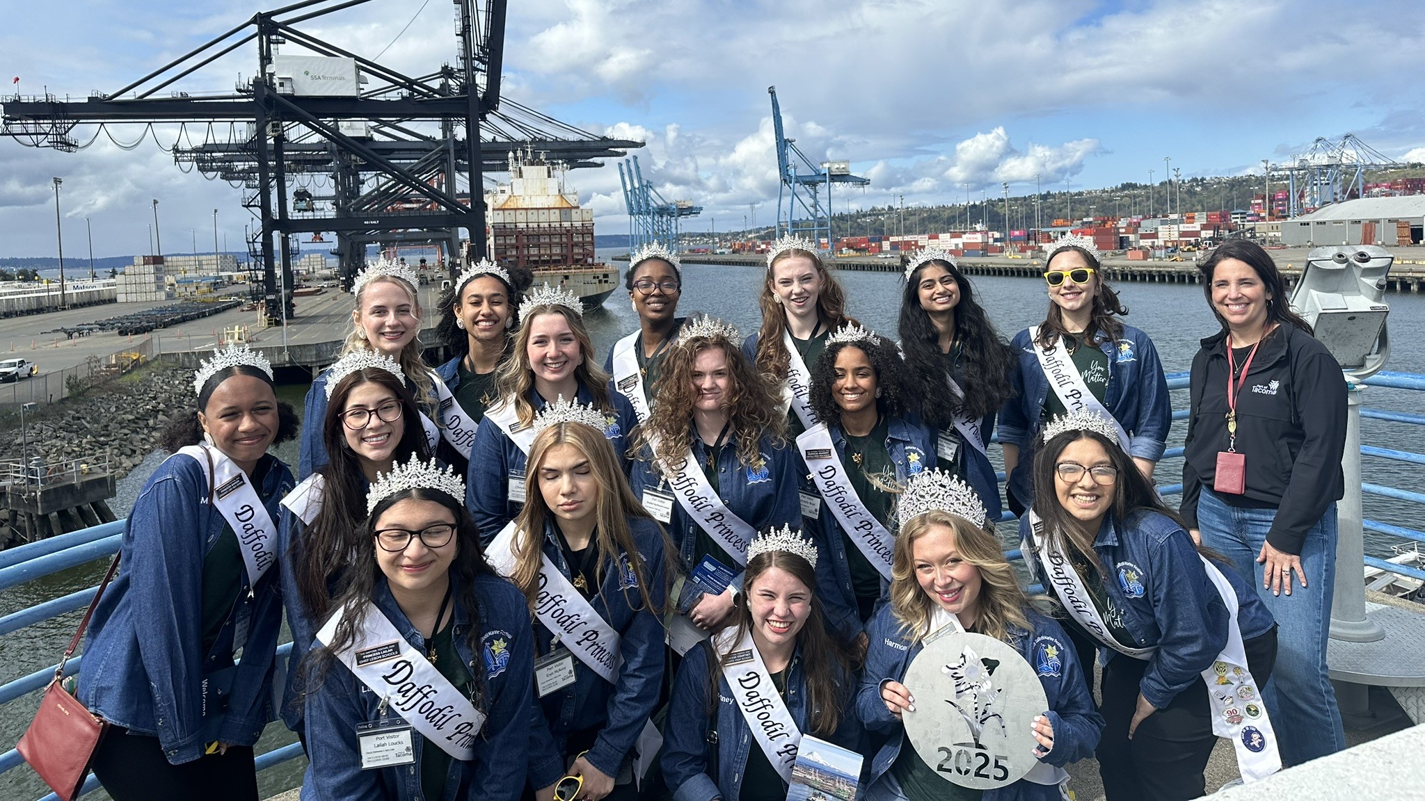 A group of young women from the Daffodils parade stand in front of a Port terminal.